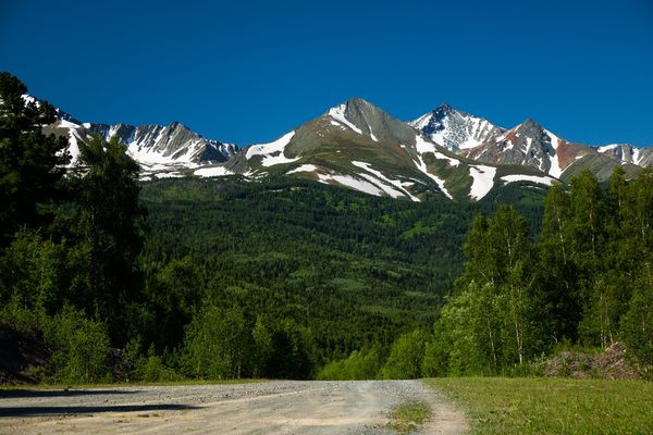 Mountain road to the base below snowy peaks