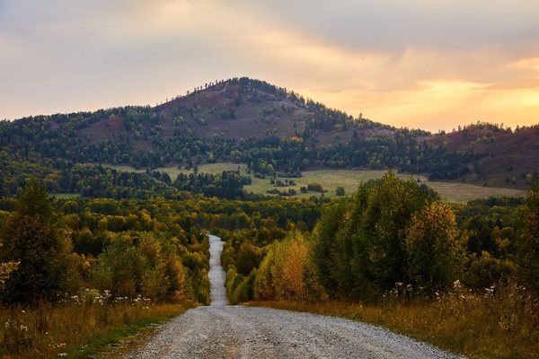 Straight road towards the mountain at sunset